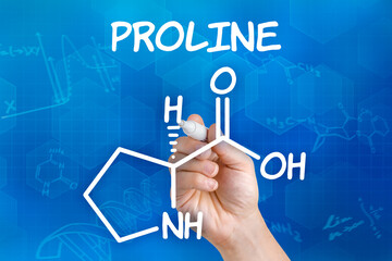 Hand with pen drawing the chemical formula of proline