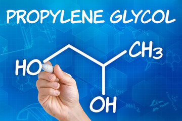 Hand with pen drawing the chemical formula of Propylene glycol