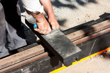 Worker cutting damping material for tram tracks