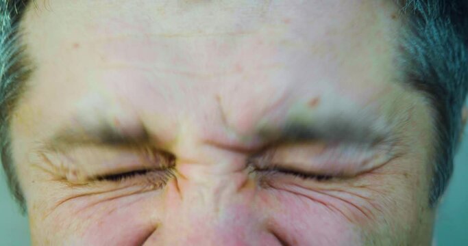 Close-up of an eye of middle-aged man - he squints and tries to see something, then puts on glasses and looking at camera. Vision health concept.