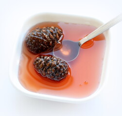 Pine cones jam on white background, on table. Top view.