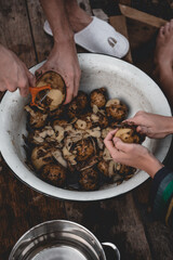 Aesthetic Shot of Two People Peeling Potatoes in a Big Bowl. Dirty Potatoes Being Prepared.