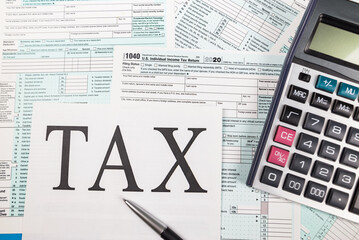 Top view of tax forms 1040 with calculator and pen