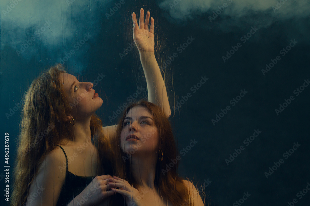 Wall mural two beautiful redhead freckled women with long natural curly hair posing in smoke, darkness, warm an