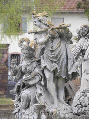 Steinstatuen musizierender Damen mit Querflöte im Schloßgarten Veitshöchheim (Bayern, Deutschland) als Teil eines Brunnens
