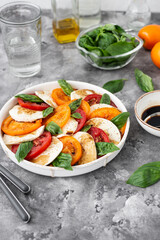 Caprese salad with mozzarella, basil and fresh garden tomatoes. Delicious italian caprese salad with tomatoes, mozarella, basil leaves, olive oil