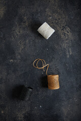 Skeins with threads. Dark moody black with grey concrete texture or background. With place for text...