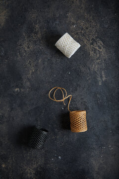 Skeins with threads. Dark moody black with grey concrete texture or background. With place for text and image