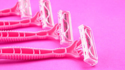 New pink disposable razors for safe shaving of female skin.Razor for smooth shaving. Sharp razors for personal hygienic routine. selective focus.
