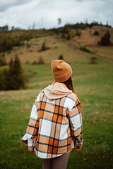 Young woman in autumn outfit walking at mountain area