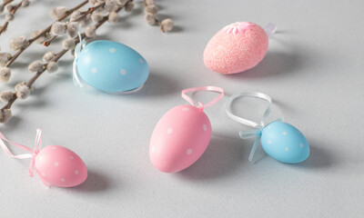 Easter concept, pussy willow, pink and blue eggs on light pastel background