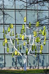 stylized tree with a steel trunk, equipped with a green plastic leaf functioning as so many silent...