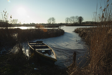 A boat at the edge of a frozen lake, Stankow, Poland