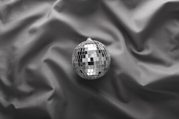 Mirror disco ball on gray crumpled silk background