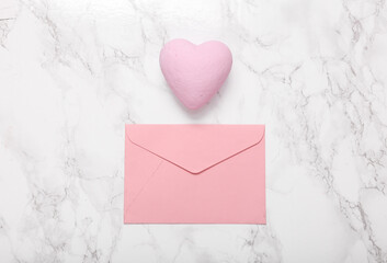Pink envelope with heart on marble background