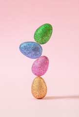Colorful glitter easter eggs against pastel pink background. Happy easter trendy concept.
