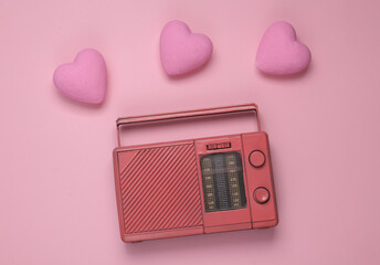 Retro fm radio receiver with hearts on a pink background. Romantic melody. Top view