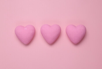 Three pink hearts on a pink background. Minimal love still life