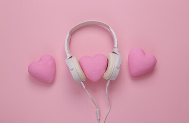 Headphones with hearts on a pink background. Romantic melody. Top view