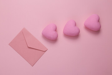 Envelope with hearts on a pink background. Love concept. Top view