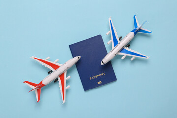 Passenger airplanes with passport on blue background. Travel concept. Flat lay, top view