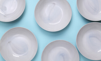 Set of empty ceramic bowls on a blue background. Top view