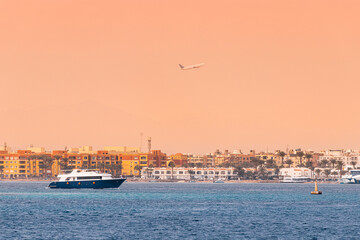 Fototapeta na wymiar Transportation in resort town of Hurghada, Egypt - cruise ships and flying airplanes