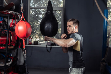 Athlete boxer training punches with a punching bag