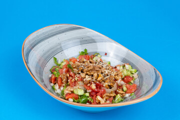 Cropped view of walnut salad shot from opposite or side angle on isolated blue background.