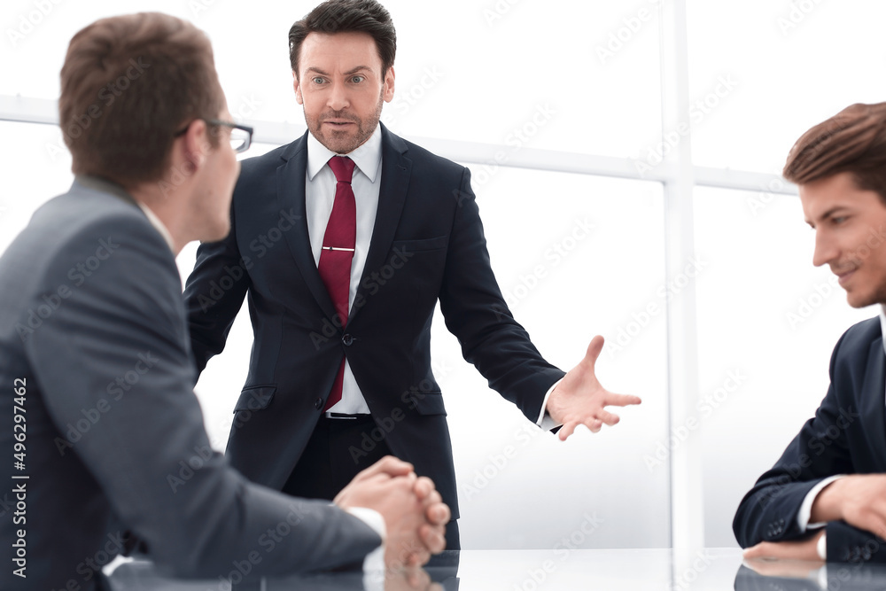 Sticker businessman talking with employees at a working meeting