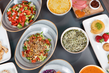 Top view shot of shepherd's salad, walnut salad, lentil soup, side dish and highland soup at iftar dinner table in isolated setting.