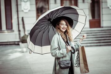 Attractive woman in autumn clothes with umbrella in the city.