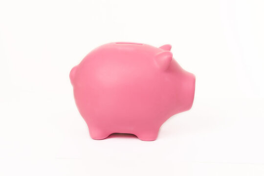 Photo of a pink piggy bank for coins isolated on white background with copy space. Money and finance concept