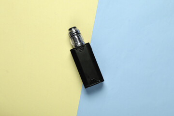 Vaping device (electronic hookah or cigarette) on yellow blue background. Top view