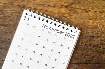 November 2022 desk calendar on wooden background.