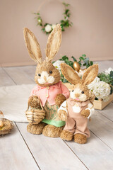 Easter hay bunnies: mother and son in an Easter decorative composition, eggs, flowers.