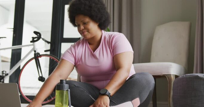 Video of midsection of plus size african american woman in sport clothes preparing for exercising