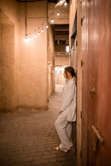 Fototapeta na wymiar Woman tourist walking in Al Seef Meraas Dubai - old historical district with traditional Arabic architecture