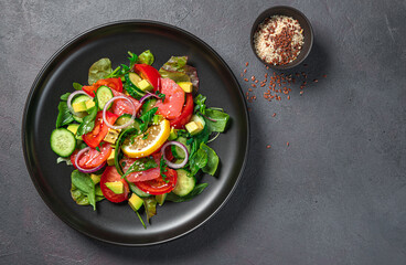Salad with salmon, vegetables, fresh herbs and sesame and flax seeds. Healthy food.