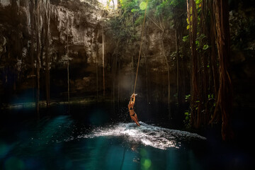 Cenote Ik-Kil Yucatan. Girl on a bungee. Mexico. - obrazy, fototapety, plakaty