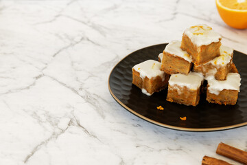 Vegan tofu and carrot cake with frosting. Cut cake cubes in tower.