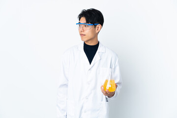 Young Chinese scientific man isolated on white background looking to the side