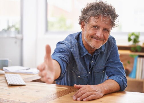Extending a warm welcome. Portrait of a mature businessman extending his arm for a handshake.