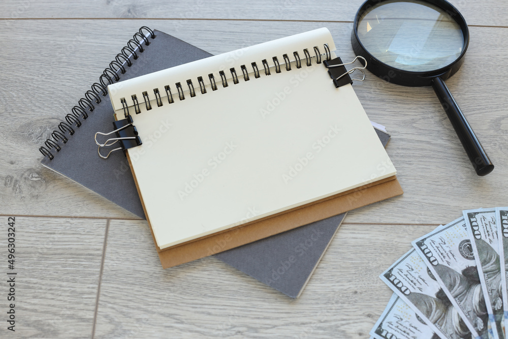 Poster office desk with supplies. view from above. copy space for text. magnifier money, blank notepad with