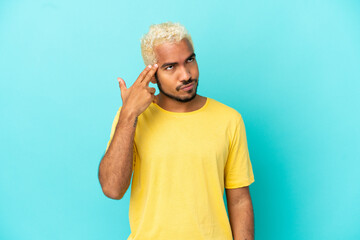 Young Colombian handsome man isolated on blue background with problems making suicide gesture