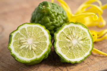 Naklejka na ściany i meble Fresh bergamot fruit with cut in half on wooden background.