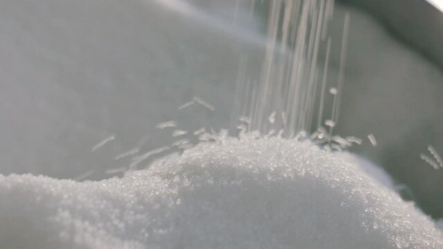 Polypropylene granules. Falling polypropylene granules, slow motion. Polypropylene granules close-up. Nonwoven Fabric Factory