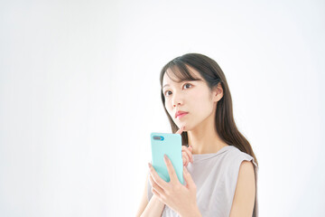 女性　スマホ　考える　白背景