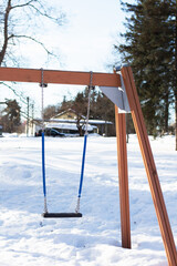 Swing on the children playground in winter with snow