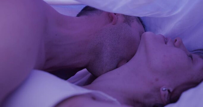 close-up of passionate kisses of a young couple in bed. Couple have love